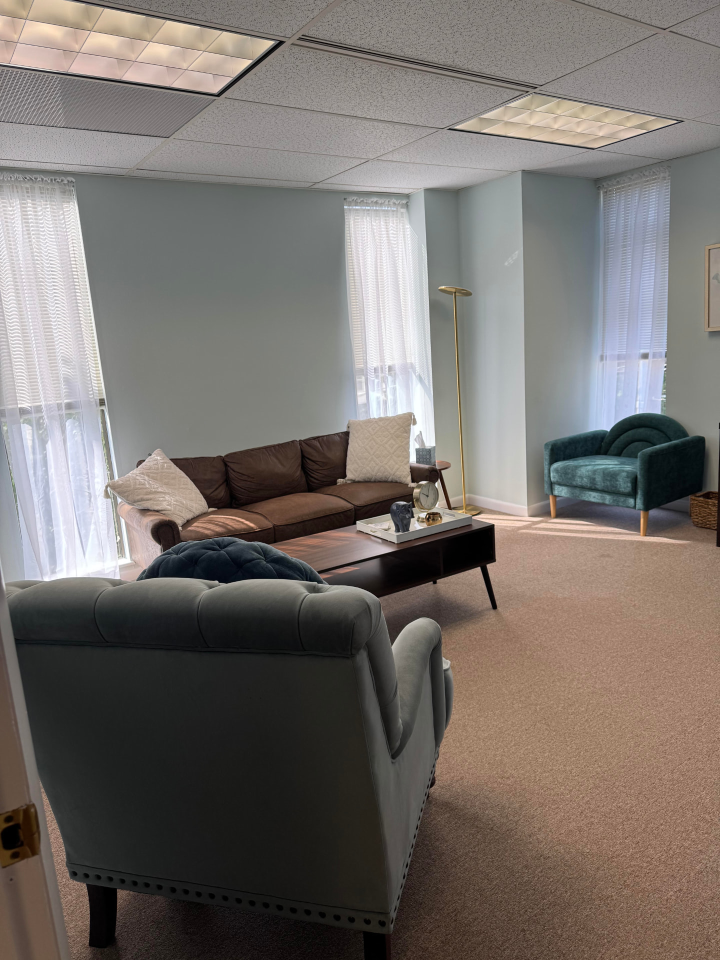 Adult office with a leather sofa, armchairs, and a coffee table